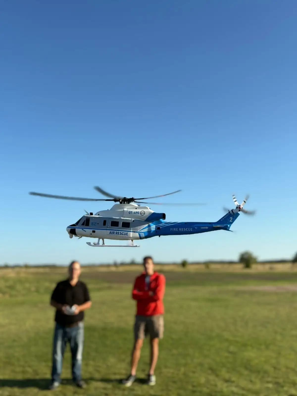 Pilotos de ChoppersRC volando un helicóptero RC en un campo abierto